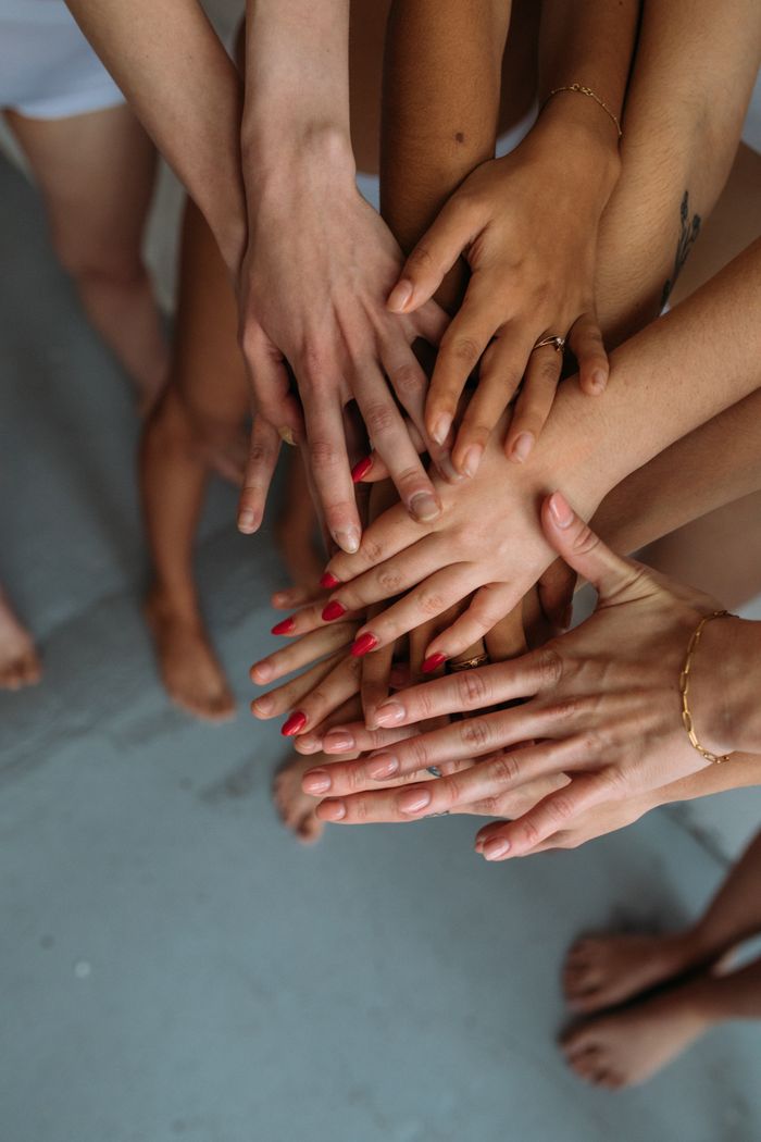 services-02 Close-up of diverse hands stacked together symbolizing unity and collaboration.